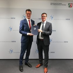 NVR-Verbandsvorsteher Stephan Santelmann und NRW-Verkehrsminister Hendrik Wüst mit dem Förderbescheid